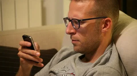 A man on sofa with smartphone Stock Footage 11235815