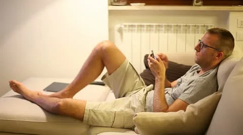A man on sofa with smartphone Stock Footage 11235921