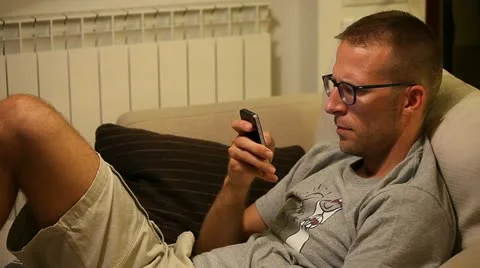 A man on sofa with smartphone Stock Footage 11236517