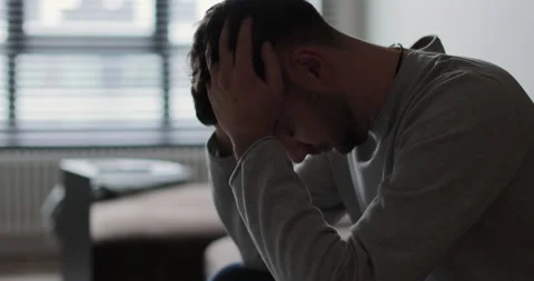 Man on sofa, unhappy upset thinking suffering from relationships problems. Stock Footage 302260912