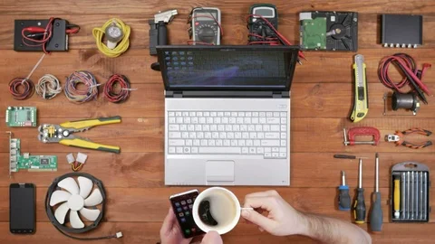 Man software engineer working at a desk with a phone, a laptop and a cup of Stock Footage 72414787
