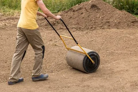 A man with a soil roller at work Foto stock