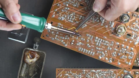 Man soldering components on electronic circuit board with soldering iron Stock Footage 344765115