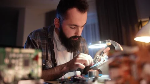 Man soldering electronic components in a home workshop Stock Footage 304618497