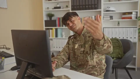 Man soldier in camouflage uniform points hand to computer monitor at desk, .. Stock Footage 337376584