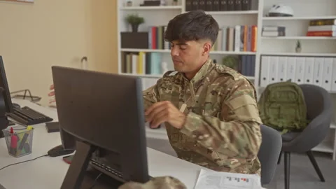 Man soldier typing at computer with dogtags visible at an office desk in bu.. Stock Footage 339197881