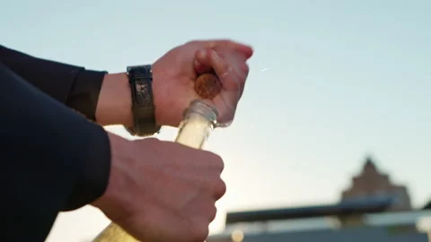 A man solemnly opens a bottle of champagne. Foam, splashes, pours over the edge Stock Footage 201469123