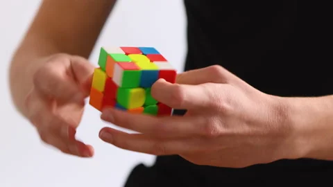 Man solves a Rubik's Cube quickly on white background Stock Footage