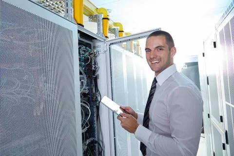 Man solving a problem with wires in a modern datacenter server room Stock Photos