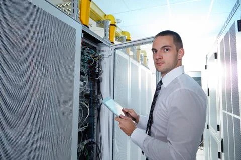 Man solving a problem with wires in a modern datacenter server room Stock Photos