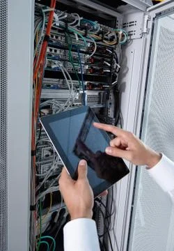 Man solving a problem with wires in a modern datacenter server room Stock Photos