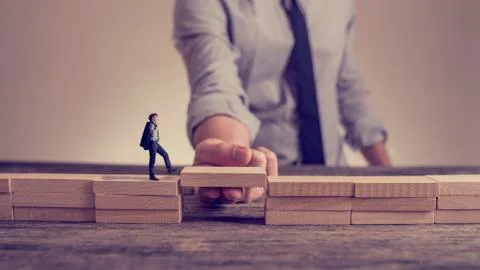 Man solving problems by building bridge with wooden block Stockfoto's