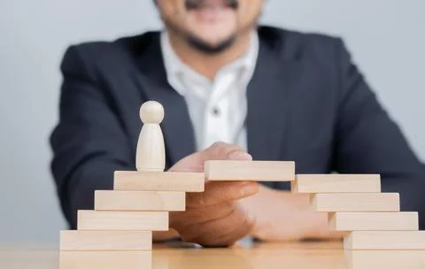 Man solving problems by building bridge with wooden block to span a gap for.. Fotos de archivo