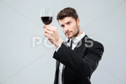 Man sommelier tasting and looking at red wine in glass Stock Photos