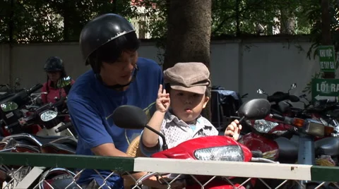 Man with son on moped in Saigon Stock Footage 61297144