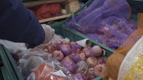 A man is sorting onions in a store. Shopping during the quarantine period, a man Stock Footage 129959243