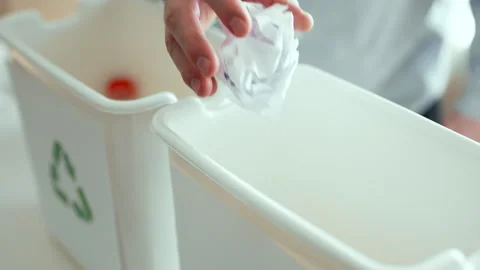 Man sorting plastic bottles and paper waste into recycling bins at home kitchen, Stock Footage 330883464