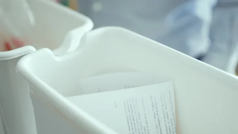 Man sorting plastic bottles and paper waste into recycling bins at home kitchen, Stock Footage 330889250