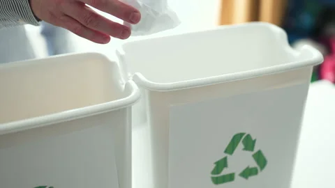Man sorting plastic bottles and paper waste into recycling bins at home kitchen, Video stock 330889400