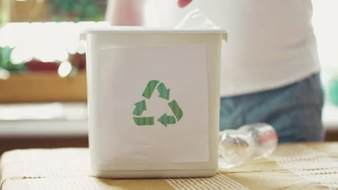 Man sorting plastic bottles and paper waste into recycling bins at home kitchen, Stock Footage 332674101