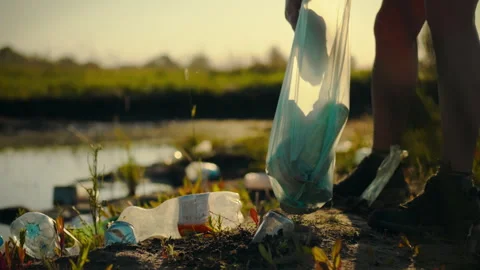 A man sorts plastic bottles and other waste and places it in a garbage bag. Stock Footage 276103882