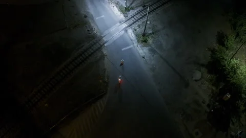 Man in space suit inspects object next to train track, aerial descend Stock Footage 296571406