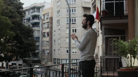 Man in Spain clapping on the balcony to the staff who fight the coronavirus Stock Footage 127934523