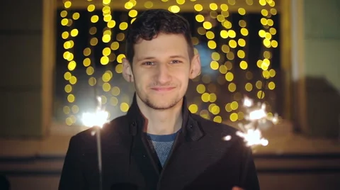 Man with a sparkler in hand bokeh background. Stock Footage 43571976