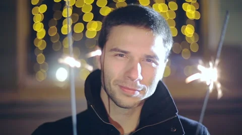 Man with a sparkler in hand bokeh background. Close up Stock Footage 43573906
