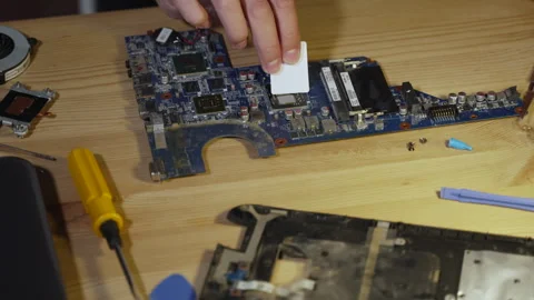Man with spatula evenly distributes thermal paste over surface of processor. Vídeo Stock 248527854