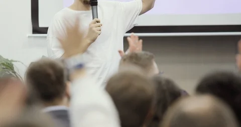Man speaker talking in large audience rising hand and viewers repet after him. Stock Footage 120131956