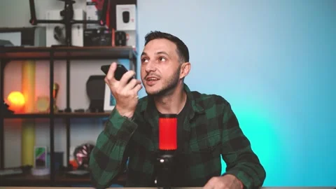Man Speaking to AI Assistant on Smartphone While Holding It Near His Face at Stock Footage 310359379