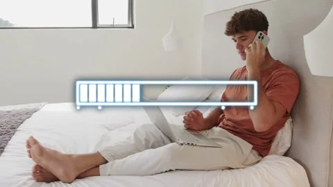 Man speaking on phone while tapping laptop, uploading project for remote work, Stock Footage 333657143