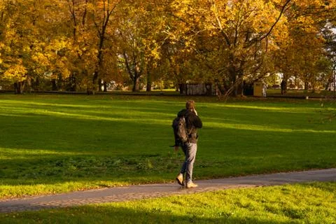 A man speaking on a phone while walking on Park Letna in Autumn 2020 on Prague Stock Photos