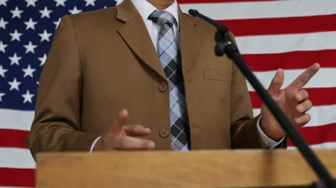 Man speaking at podium, flag background Stock Footage 62279793