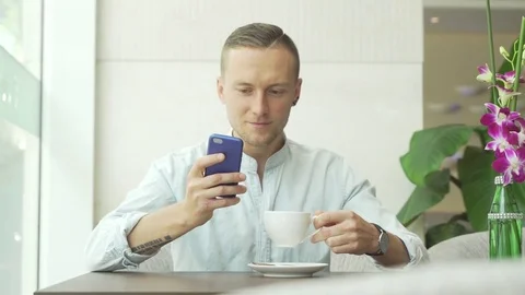 Man speaking on smartphone and drinking coffee Stock Footage 79045321