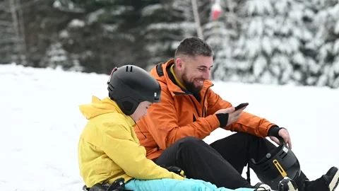 A man speaks on his phone while sitting beside a child wearing Stock Footage 338438551