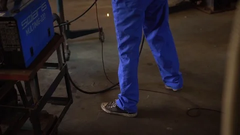 A man in special clothes welding and repair car. Professional car mechanic Stock Footage 104922896