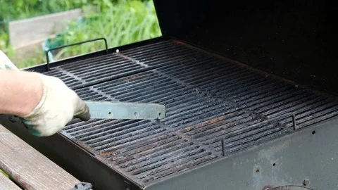 A man with a special tool to clean the grill. Stock Footage 130669638