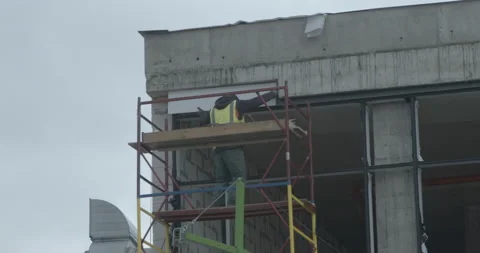Man in special uniform builds window installing in building Stock Footage 171161527