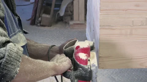 A man in a special uniform with his bare hands firmly holding an electric planer Stock Footage 62008819
