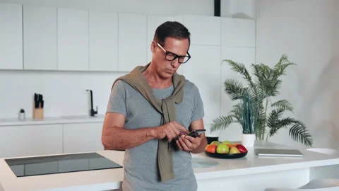 Man with spectacles relaxing sitting on couch while looking at mobile phone Stock Footage 219548611