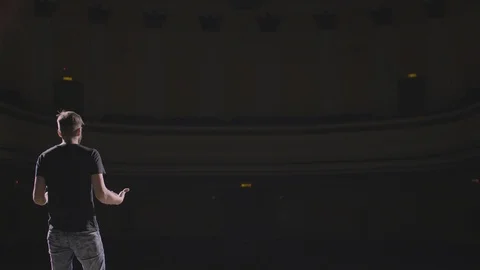 Man speech standing on the stage in big dark hall Stock Footage 92982345