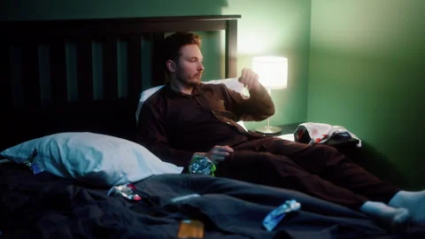 Man spending night in bed with smartphone and chips Video stock 319442742