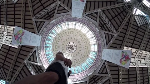 Man Spinning Around Staring At Ceiling Of Central Market, Valencia, Spain, 2017 Stock Footage 84581836