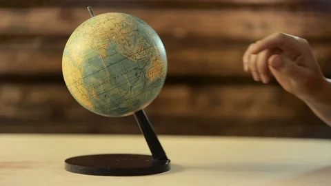 Man spinning a globe and pointing on it Stock Footage 90777534