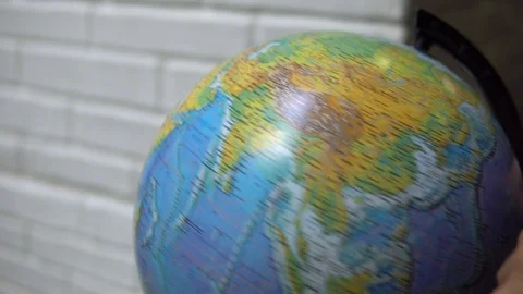 Man spinning a globe and pointing on it. Man choosing his next travel on a Stock Footage 120305776