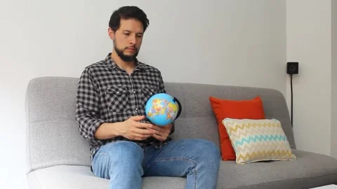 Man spinning with his hand a world globle in a concentrating attitude Vídeo Stock 340583503