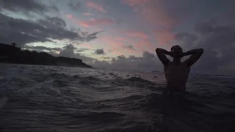 Man Splashes Water Over Head in Red Sunset Sea Stock Footage 79276582