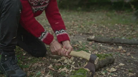 Man Splitting apart Mossy Log with Axe during Survival Trip in Wilderness Stock Footage 317339344